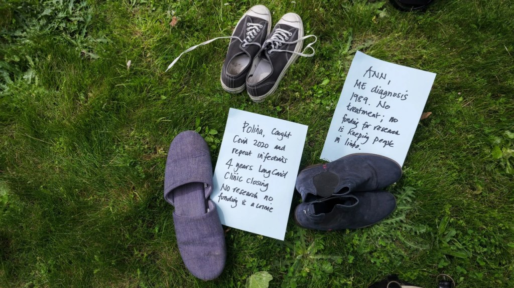 Shoes on grass with name tags and 'years been ill' on them along with demands for funding
